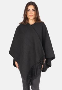 Schwarzer Wollponcho mit einem drapierten Design, der Fransenakzente am unteren Rand aufweist. Glatte Textur und lockere Passform.