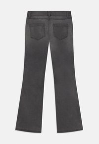 Hallide viigatud teksad, millel on sile tekstuur, kahel tagataskul ja õmblused. Kangas näib hemist veidi pleekinud.