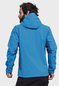 Blaue wasserdichte Jacke mit Kapuze, strukturiertem Stoff, kontrastierenden, dunkleren blauen Seitenpaneelen und verstellbaren Bündchen. Glatte Oberflächentextur.