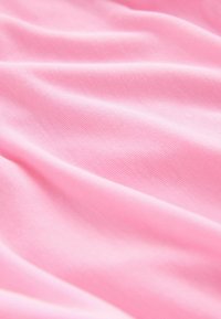 Tissu rose doux avec des plis délicats et une texture lisse légèrement côtelée.