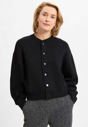 Schwarzer Cardigan mit rundem Ausschnitt, Knopfverschluss und geripptem Saum. Hergestellt aus strukturiertem Strickstoff; hat überschnittene Schultern und eine lässige Passform.