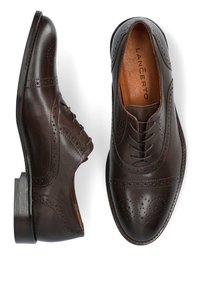 Brązowe skórzane buty brogue z perforowanymi detalami, zaokrąglonym noskiem i gładkim wykończeniem. Posiadają piętę na klocku i sznurowany fason.