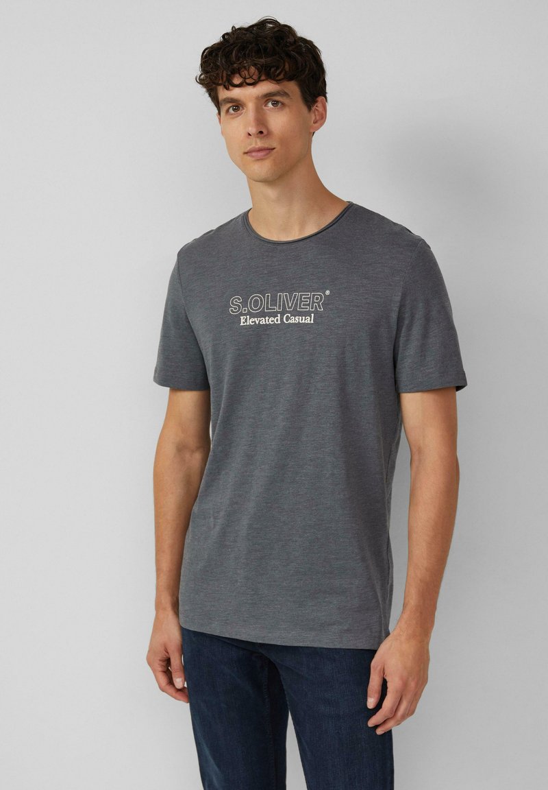 Szara bawełniana koszulka z okrągłym dekoltem. Posiada białe logo "S.Oliver Elevated Casual" na klatce piersiowej. Krótkie rękawy, miękka struktura.