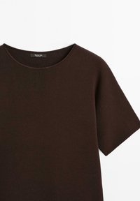 Brauner kurzer Pullover mit Rundhalsausschnitt, aus strukturiertem Stoff. Etikett sichtbar in der Mitte des Ausschnitts. Einfaches, sauberes Design.