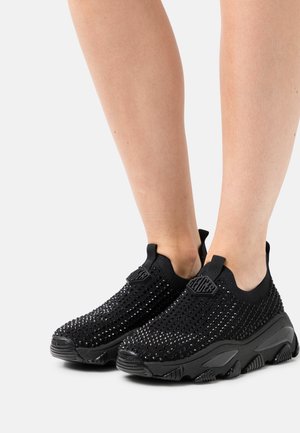 Schwarze Slipper-Sneaker mit einem Obermaterial aus Mesh, das ein strukturiertes Muster aufweist, und einer groben schwarzen Sohle. Enthält ein Logo-Detail auf der Zunge.