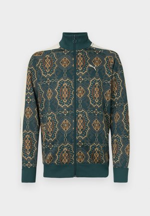 En zip-up jakke med en mørk teal-base og intrikate gull- og oransje blomster mønstre. Ribbestrikkede mansjetter og krage, myk tekstur.