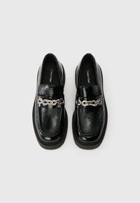 Mustad nahast loafers läikiva viimistlusega, millel on hõbedane kettisüvenemine vampi kohal ja veidi tõstetud must tald.