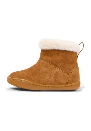Bottine en suede marron avec un revers en fausse fourrure blanche, bout arrondi et semelle texturée. Inclut une languette à l'arrière pour un enfilage facile.