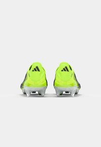Adidas soccer cleats in neon yellow and black, featuring a sleek design, lightweight material, and clear plastic studs for traction.
