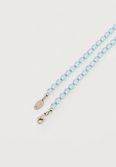 Ανοιχτό μπλε αλυσίδα με πολύεδρα χάντρα, ασημένιο κούμπωμα τύπου αστακός και μικρή οβάλ μεταλλική ετικέτα σε απλό λευκό φόντο.