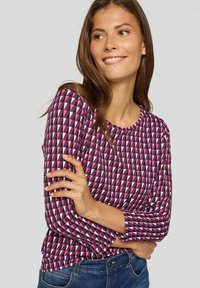 Langärmliges Oberteil in pink-schwarzem geometrischem Muster, aus weichem Stoff mit rundem Halsausschnitt und taillierter Passform.