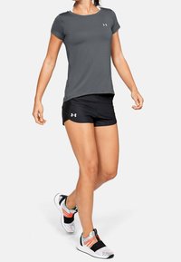 Camiseta atlética de manga corta gris combinada con pantalones cortos negros y zapatillas de running multicolores con textura de malla y acentos elásticos.