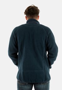 Pullover in pile blu navy con colletto alto, tessuto testurizzato e maniche lunghe. Presenta una linea dritta e dettagli cuciti sul retro.