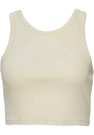 Lõigatud tank top pehmes kreemjas kangas, millel on sooniline tekstuur ja õrn broderie logo ees. Minimalistlik disain.