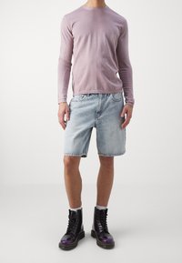 Light purple long-sleeve shirt, faded blue denim shorts, and black-purple lace-up boots with a smooth finish and white socks.