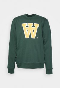 Zelená mikina vyrobená z bavlněné směsi. Na přední straně se nachází velké žluté logo "W". Žebrované manžety a lem poskytují těsný vzhled.