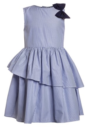 Robe sans manches rayée verticalement bleu et blanc avec jupe peplum asymétrique et nœud bleu foncé sur l'épaule gauche.