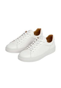 Zapatillas blancas de cuero liso, con una suela de goma texturizada, punta redonda, seis agujeros para los cordones y un forro interior marrón.