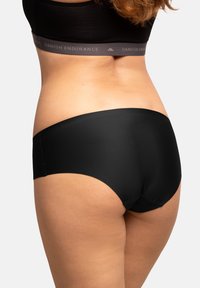 Slip neri senza cuciture con una texture liscia e una fascia larga che presenta il logo "DANISH ENDURANCE", progettati per comfort e vestibilità.