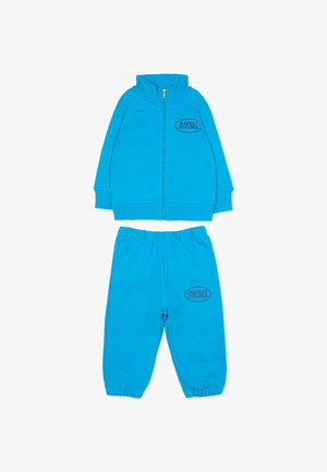 Blauwe trainingspakset gemaakt van zachte stof, met een jas met ritssluiting en hoge kraag en bijpassende broek; beide voorzien van "DIESEL" logo-accenten.
