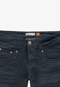 Donkerblauwe denim jeans met een gladde textuur, vijf-pocket ontwerp en koperen hardware aan de taille en de randen van de zakken.