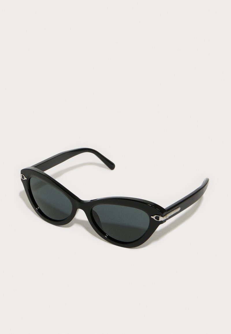 Occhiali da sole neri a forma di occhio di gatto con lenti scure, montatura in plastica lucida e dettagli in metallo argento sulle tempie. Texture liscia su tutta la superficie.