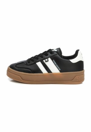 Zapatillas negras con rayas blancas, material sintético texturizado, punta redonda, cuello acolchado y suela de goma.