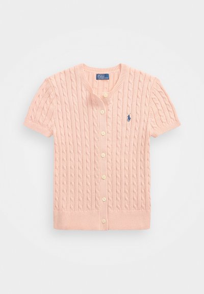 Kratās piedurknēs, gaiši rozā adīts džemperis ar noapaļotu apkakli, četriem pogām un zilu logo kreisajā krūtī.