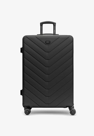 Maleta negra de concha dura con textura de chevron, equipada con un mango telescópico y cuatro ruedas giratorias de 360 grados.