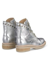 Bottes chelsea en cuir argenté avec lacets à l'avant, bout rond, œillets décoratifs et détail de semelle en bois. Accent cousu sur la tige.