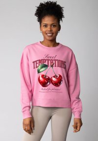 Rosa Sweatshirt mit Rundhalsausschnitt, großem Kirschenmotiv und dem Schriftzug "Sweet Temptations." Gerippte Bündchen und Saum, weiche Stoffstruktur.
