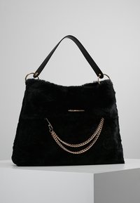 Czarna torebka z sztucznego futra z złotym łańcuszkiem i skórzanym uchwytem. Posiada miękką fakturę i przestronny design.