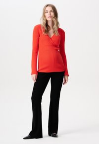 Rode geribbelde lange mouwen top met een wikkelontwerp, gecombineerd met zwarte geribbelde flare pants en zwarte puntige ballerina's. Eenvoudige, aansluitende silhouet.