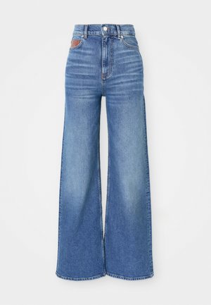 High-waisted wide-leg jeans in light blue denim with a slight fade, featuring a button closure and leather accent at the back waistband.