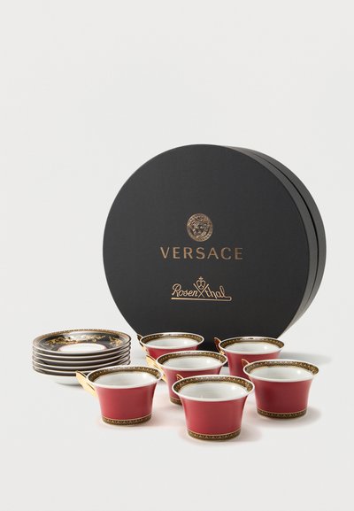 Έξι κόκκινα φλιτζάνια εσπρέσο με χρυσή διακόσμηση και έξι ταιριαστά πιατάκια δίπλα σε μια μαύρη κυκλική συσκευασία με τα λογότυπα Versace και Rosenthal.