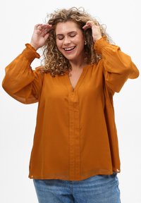 Rostorange Bluse aus leichtem Stoff, mit V-Ausschnitt, langen Puffärmeln mit gerafften Bündchen und einem entspannten Schnitt.