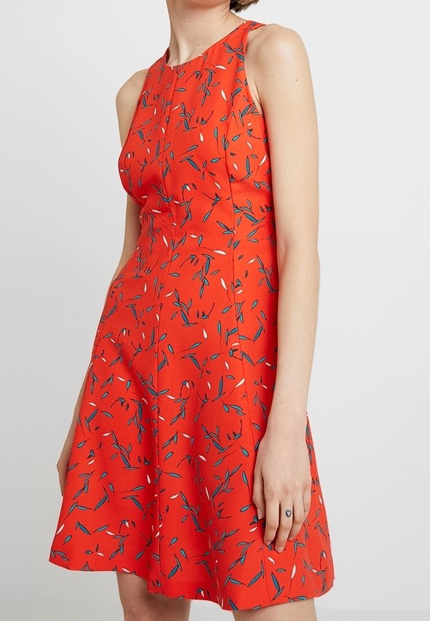 Rote ärmellose Kleid mit einem schwingenden Rock, das ein florales Muster in Blau und Weiß zeigt. Der Stoff hat eine glatte Textur.