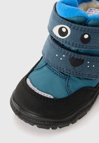 Botte pour enfant bleue et noire avec des bandes auto-agrippantes, présentant une finition texturée, un design de visage d'animal ludique et une semelle en caoutchouc pour une meilleure adhérence.