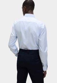 Gestreepte dress shirt in lichtblauw en wit katoen, met een spreidkraag en knoopmanchetten, gecombineerd met donkere broeken.