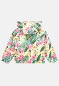 Giacca corta in tessuto giallo con una vivace stampa floreale che presenta orchidee rosa e foglie verdi. Include un cappuccio e polsini elastici.