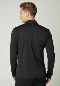Schwarzes Langarm-Sporthemd mit glatter Textur und taillierter Passform. Verfügt über Schulterpaneele, hohen Kragen und minimalistischen Stil.