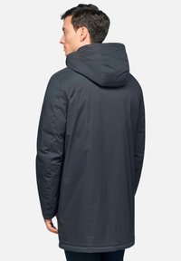 Giacca a vento grigio scuro con una texture matte liscia, che arriva a metà coscia, dotata di cappuccio sicuro e dettagli di cucitura sottili.