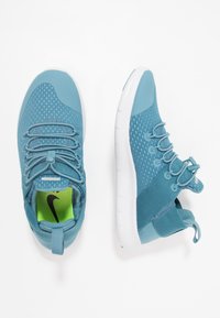 Tyrkysové atletické tenisky s pletivovým svrškem, zaoblenou špičkou, elastickými tkaničkami a polstrovanou bílou podrážkou. Mají neonově zelenou vnitřní podšívku a poutko na patě.