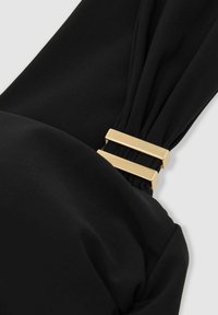 Tessuto nero con dettaglio arricciato e accessori rettangolari dorati. Texture liscia con una forma strutturata nel punto di raccolta.