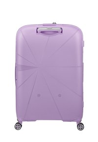 Valigia rigida viola con un design geometrico a coste, maniglia superiore e quattro ruote per la mobilità. Presenta accenti sottili e una texture liscia.