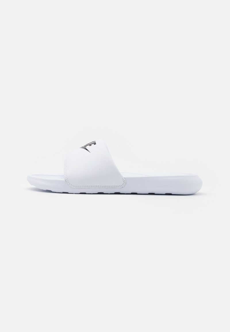 White slide sandals made of smooth synthetic material, featuring a wide strap with a logo, cushioned sole, and minimalist design.