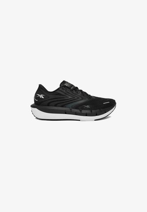 Pantof de alergare Reebok alb-negru cu partea superioară din plasă, design ondulat, închidere cu șireturi și talpă groasă amortizată.