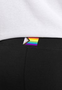 Sorte leggings med en bageste waistband-label, der har et regnbue chevron-design og tykke sømme. Stoffet er glat og strækbart.