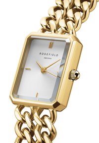 Gouden rechthoekige horloge met een glanzende ketting armband en een zilveren gestructureerde wijzerplaat. Heeft minimalistische uurmarkeringen en een kroon.