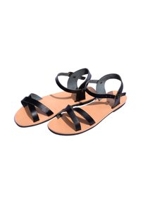 Zwarte leren sandalen met kruisende banden, een enkelbandje en een lichtbruine binnenzool. Platte zool, minimalistisch ontwerp, matte textuur.